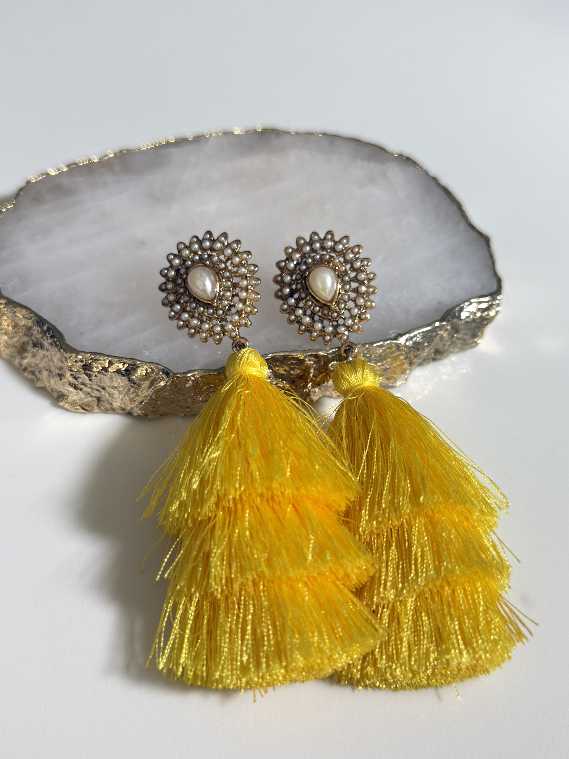 Brinco com franjas amarelas e base em pérolas