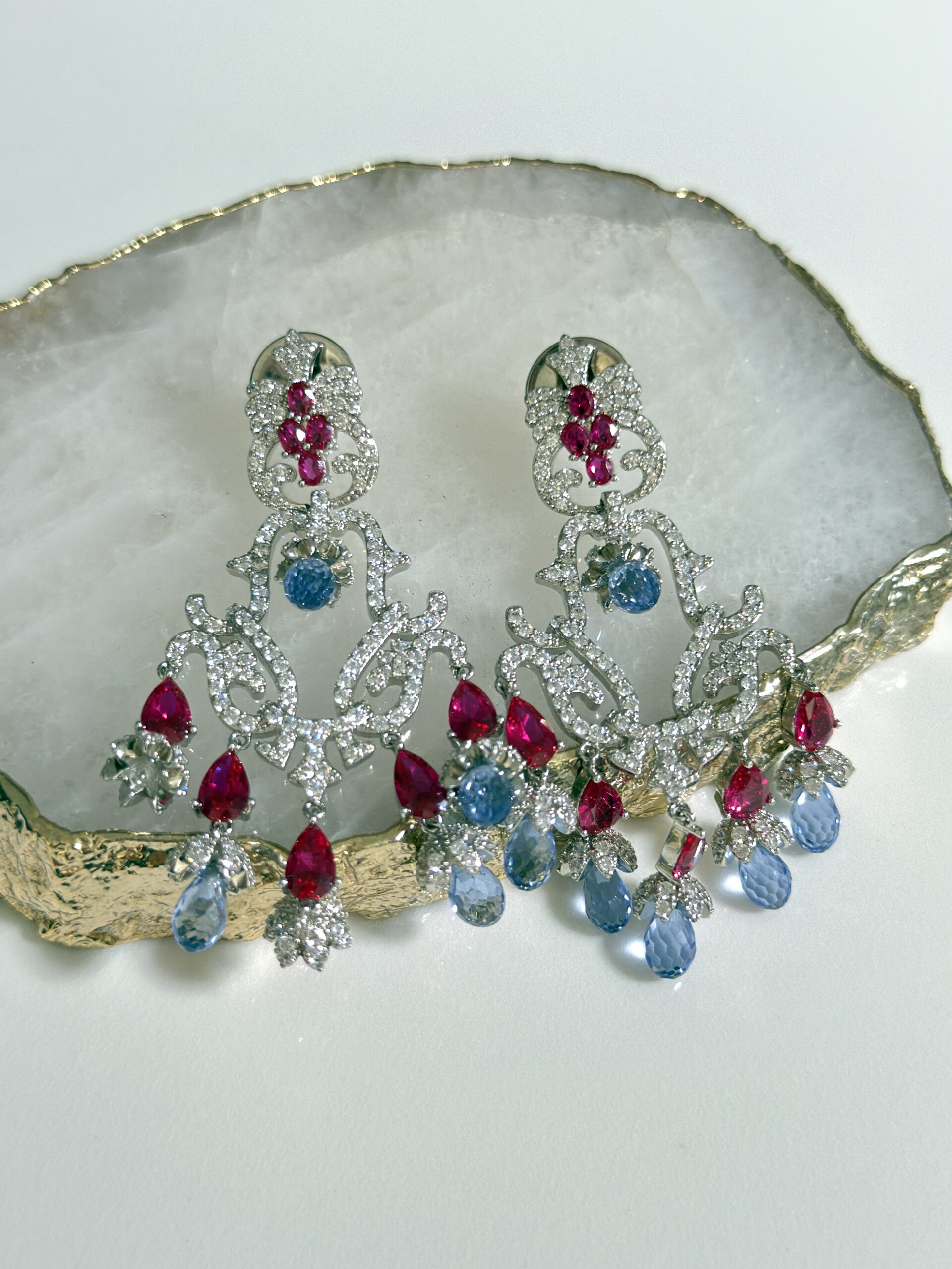 Brinco longo cravejado com pedras vermelhas e azuis